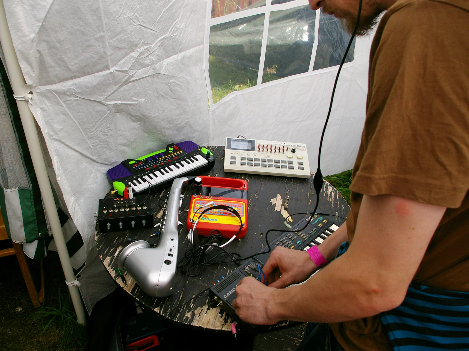 A table of modified keyboards, a drum machine and a Speak & Spell at a circuit-bending event.